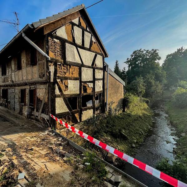 Das Bild zeigt ein zerstörtes Fachwerkhaus neben dem Steinbach mitten in Schweinheim.