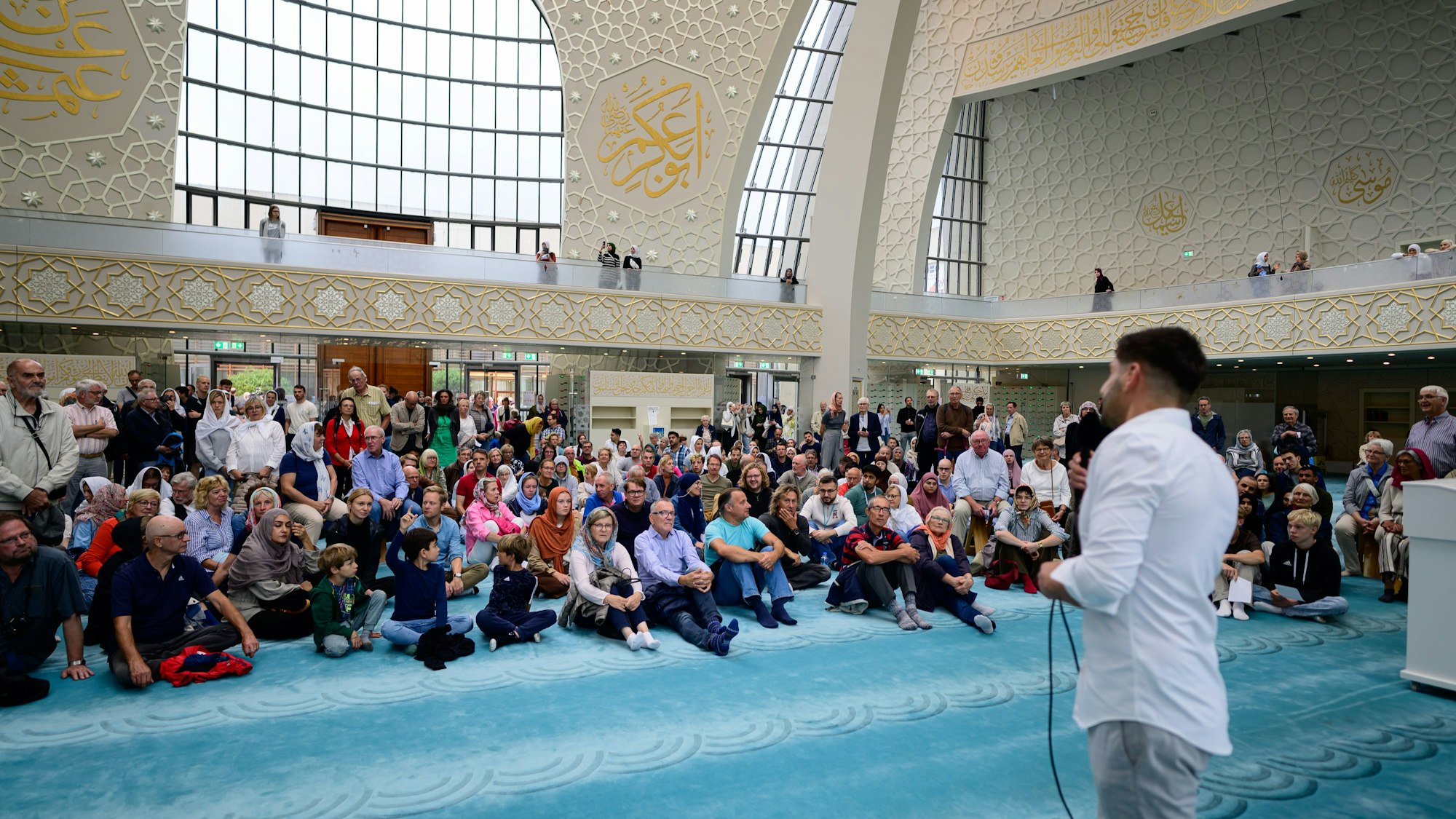 Menschen hören Erklärungen in der Zentralmoschee zu.