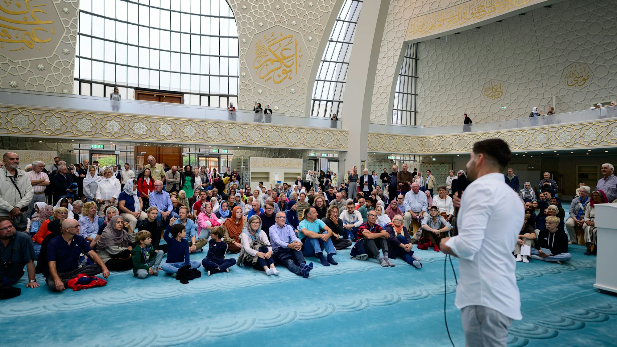 Menschen hören Erklärungen in der Zentralmoschee zu.