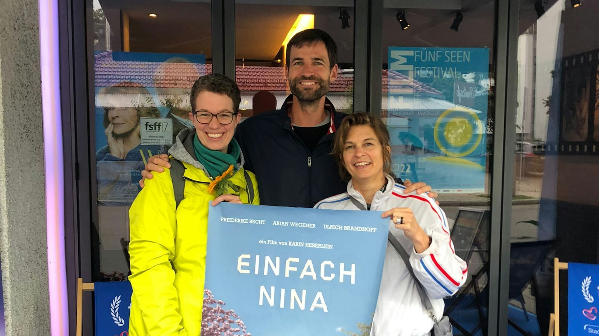 Das Autorenteam Angela Gilges (links), Karin Heberlein und Christopher von Delhaes hält das Plakat ihres Filmes „Einfach Nina“ hoch.