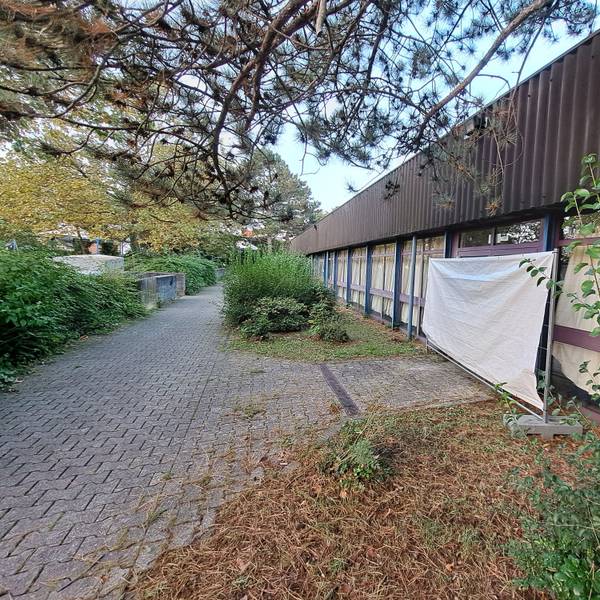Weil dort Geflüchtete untergebracht sind, sind die Fenster der Dreifachsporthalle in Mondorf mit Vorhängen verhüllt. Die Stadt will die in die Jahre gekommene Halle energetisch sanieren.