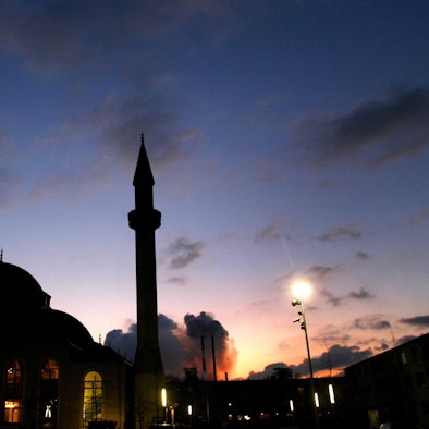 Hinter der Merkez-Moschee in Duisburg Marxloh mit dem 34 Meter hohen Minarett geht die Sonne unter.