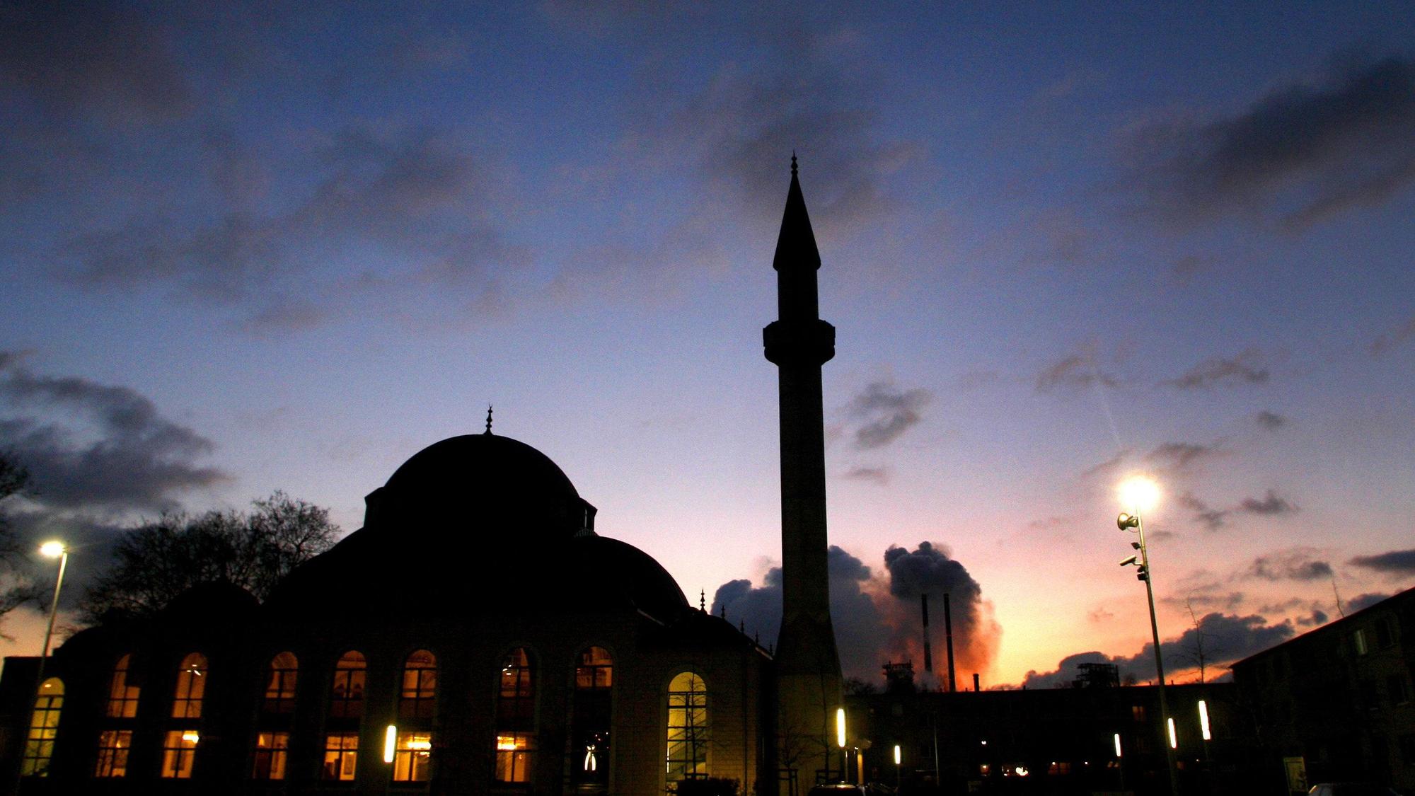 Hinter der Merkez-Moschee in Duisburg Marxloh mit dem 34 Meter hohen Minarett geht die Sonne unter.