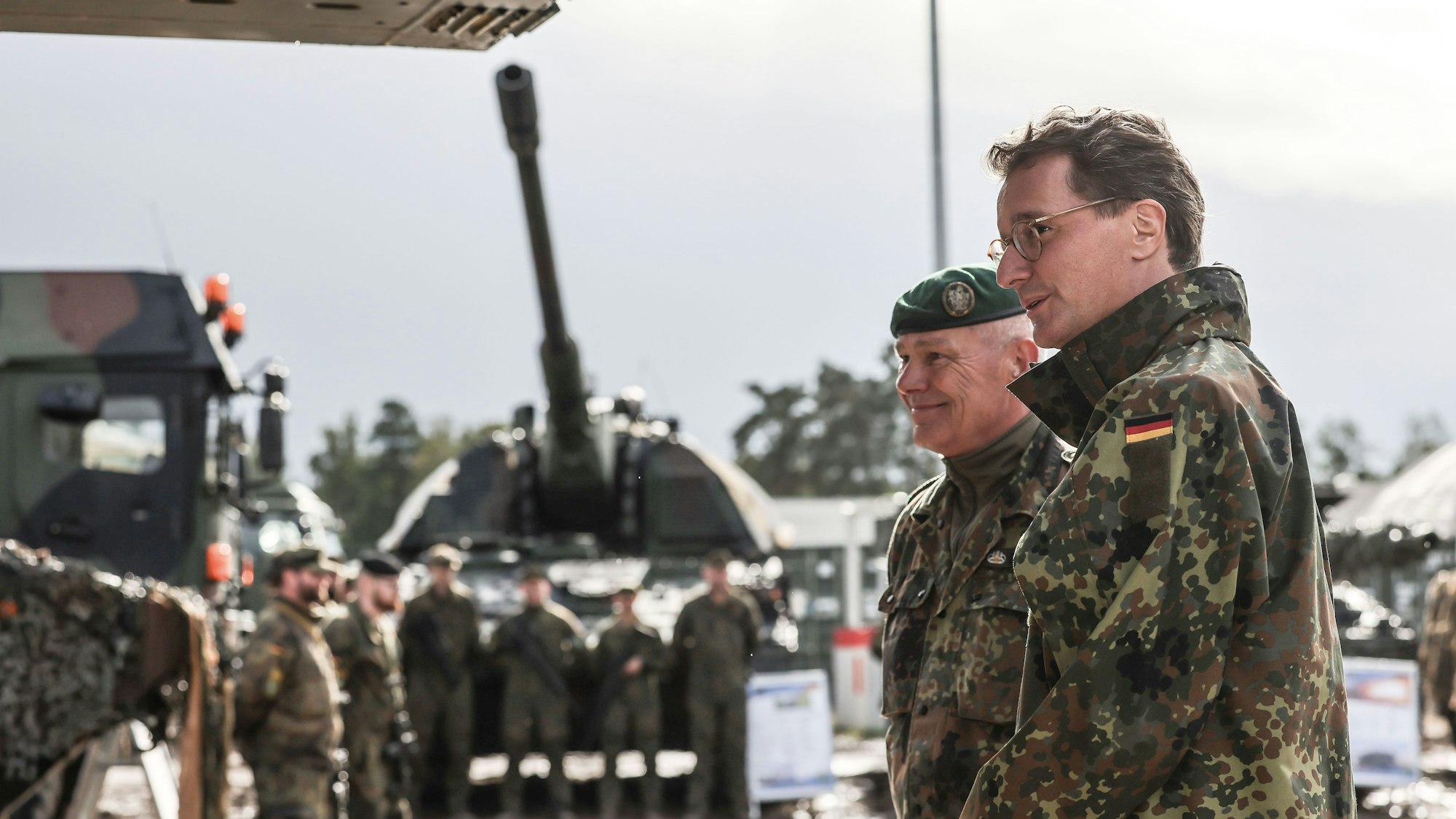 Der nordrhein-westfälische Ministerpräsident , Hendrik Wüst (r, CDU) spricht neben Oberst Klaus-Peter Berger (2.v.r.) mit deutschen Soldaten.