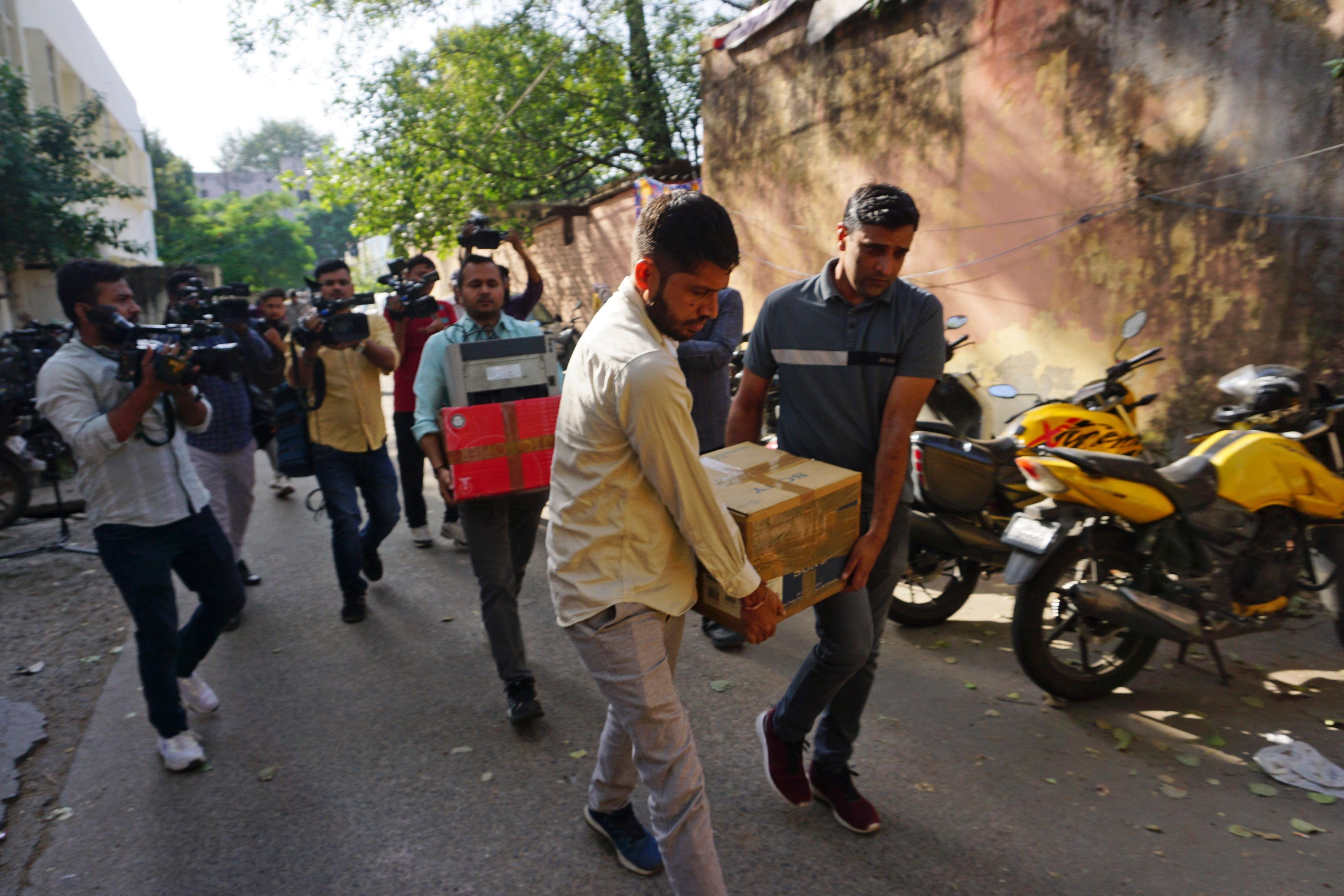 Neu Delhi: Sicherheitsbeamte tragen Kisten mit beschlagnahmtem Material nach einer Razzia im Büro von NewsClick.