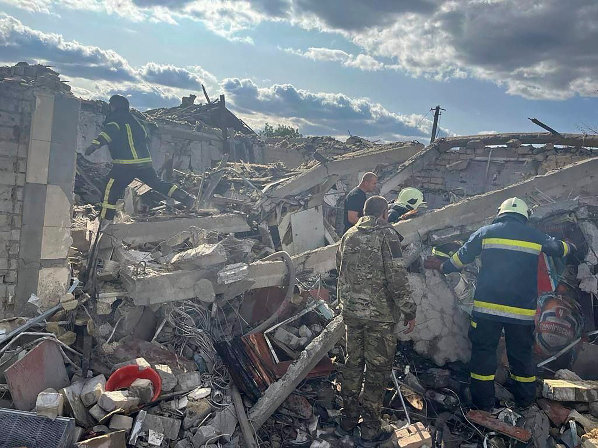 Raketenangriff auf Hroza: Ukrainische Sicherheitskräfte und Feuerwehrleute durchsuchen Trümmer nach Überlebenden.