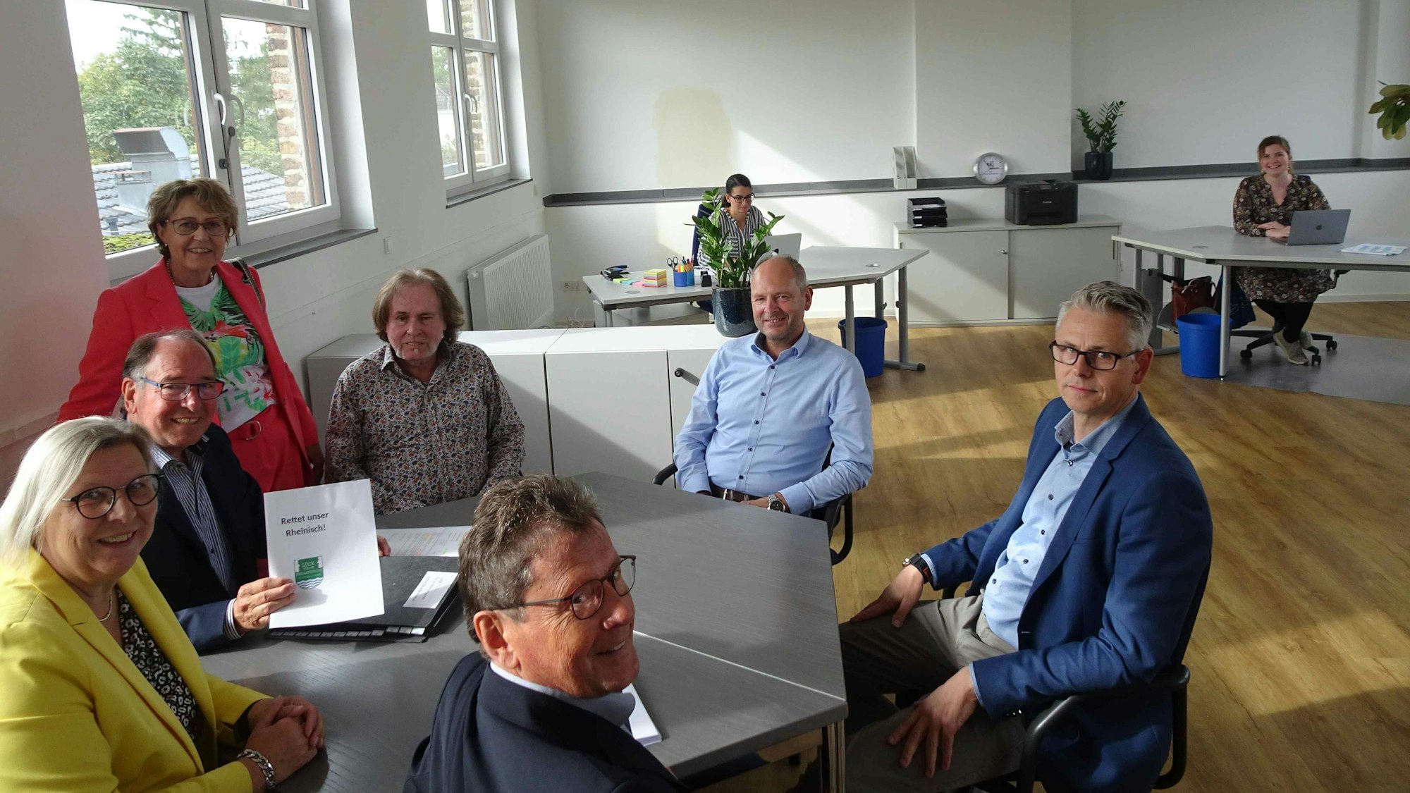 Der Verein "Lück für os Heemotsproch" um seinen Vorsitzenden Wilfried Hein (2.l.) und BM Petra Kalkbrenner (daneben in sonnengelbem Jacket) im neuen Vereinsraum im ersten Stock von Ollheims Alter Schule. Im Hintergrund die zwei wissenschaftlichen Mitarbeiterinnen Hanna Zimmermann (links) und Lisa Felden an ihren Arbeitsplätzen.