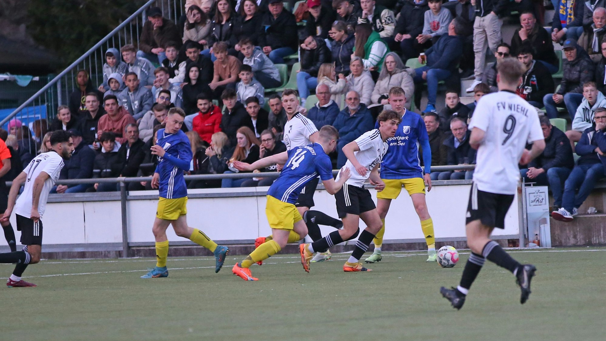 Vor einer gut gefüllten Zuschauertribüne möchte ein Nümbrechter einem Wiehler Fußballer den Ball abjagen..
