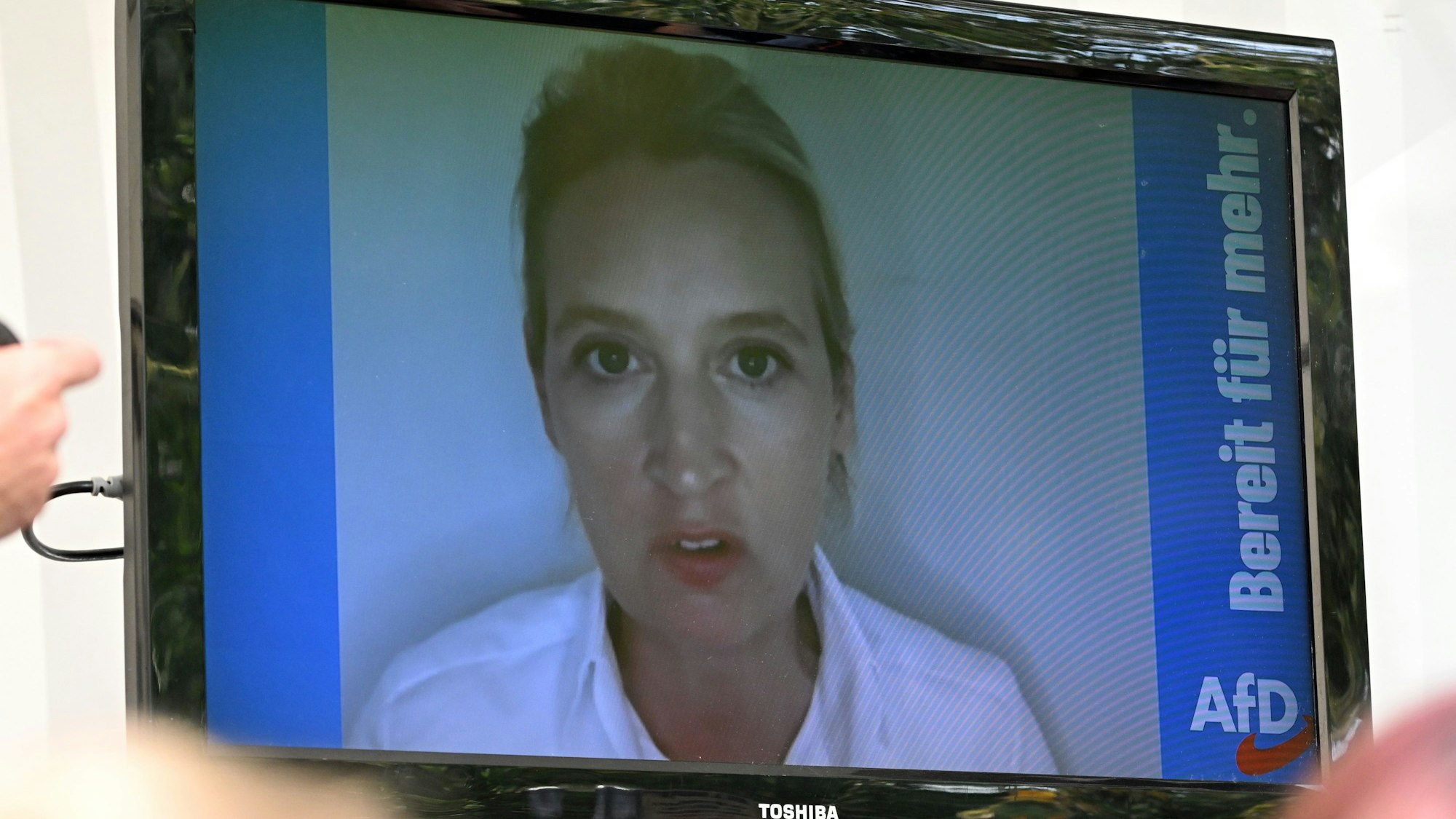 Alice Weidel, AfD-Bundesvorsitzende, wandte sich auf der Wahlkampfveranstaltung in Mödlareuth per Videobotschaft an die Besucherinnen und Besucher. Laut einem Redner soll sie sich in einem Safehouse befunden haben, tatsächlich aber war sie offenbar im Urlaub auf Mallorca.