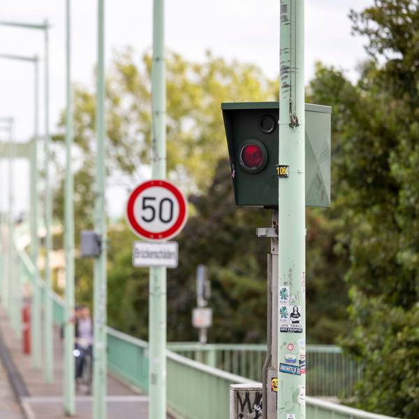 Ein Blitzer steht vor einem Schild, das auf Tempo 50 hinweist.