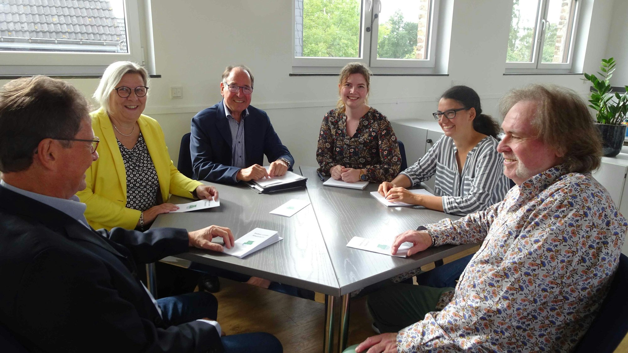 Die Mitglieder des Vereins "Lück für os Heemotsproch" im neuen Vereinsraum im ersten Stock von Ollheims Alter Schule. Am Tisch sitzen von links Schatzmeister Dieter Ramershoven, BM Petra Kalkbrenner, Vorsitzender Wilfried Hein, die wissenschaftlichen Mitarbeiterinnen Lisa Felden und Hanna Zimmermann sowie Geschäftsführer Karl-Heinz Peters.