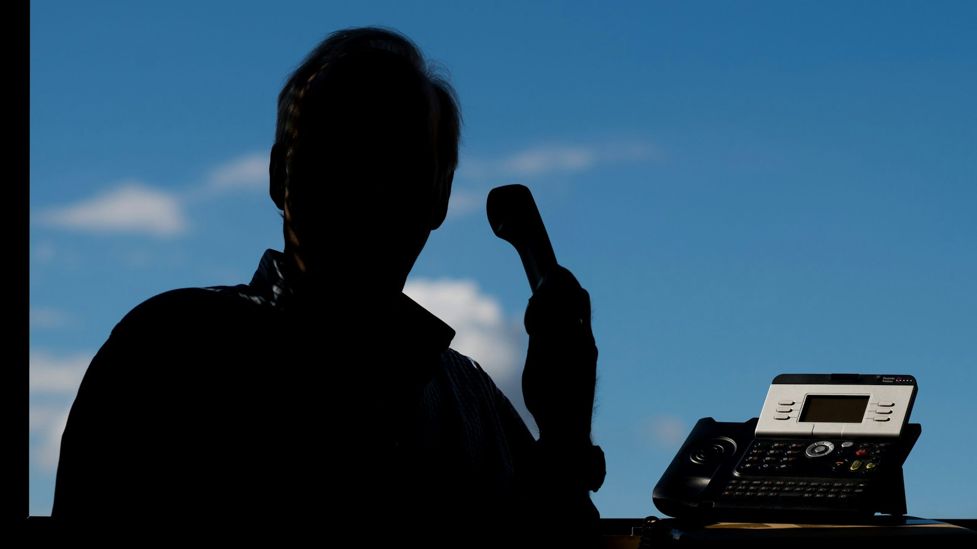 Ein Mann hält ein Telefon.