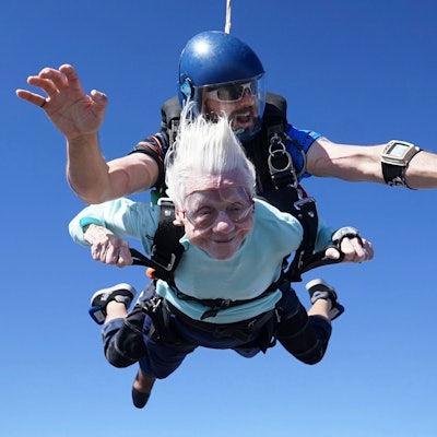 Das Foto zeigt Dorothy Hoffner, 104, die mit dem Tandemspringer Derek Baxter durch die Luft fällt, als sie am Sonntag, dem 1. Oktober 2023, bei Skydive Chicago in Ottawa, Illinois, die älteste Person der Welt wird, die mit dem Fallschirm springt