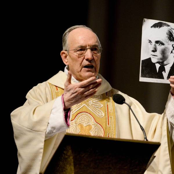 Prälat Prof. Dr. Helmut Moll 2013 im Priestergewand. Er hält ein Foto von Willi Graf in der Hand.
