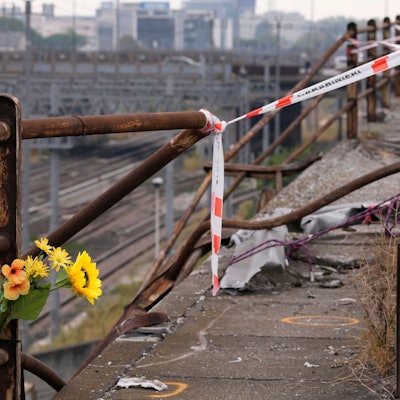 Ein Strauß Plastikblumen ist nach einem Busunglück nahe der Unfallstelle angebracht.
