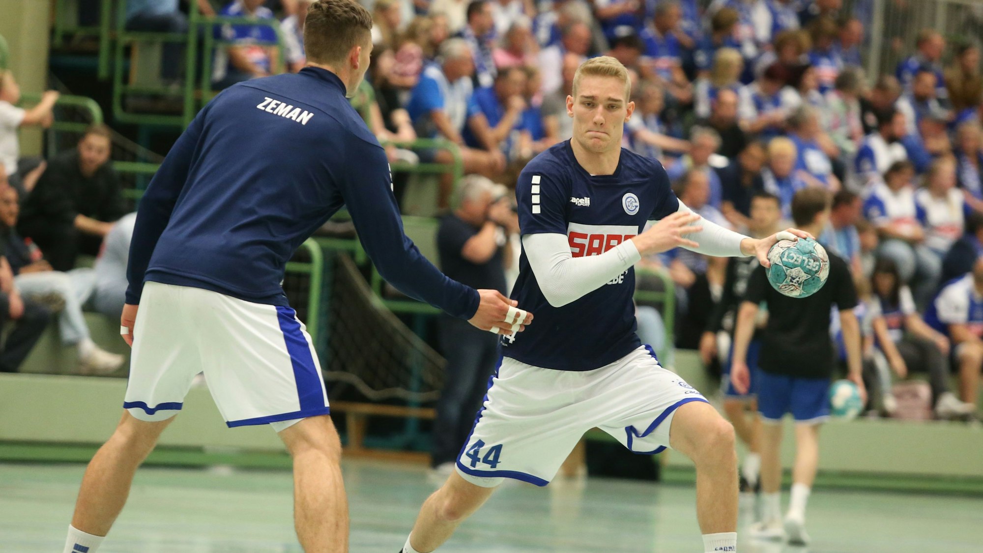 Beim Aufwärmen für das Pokalspiel in der Ratingen will Handballer Tom Jansen seinen Mannschaftskollegen Stepan Zeman umspielen.