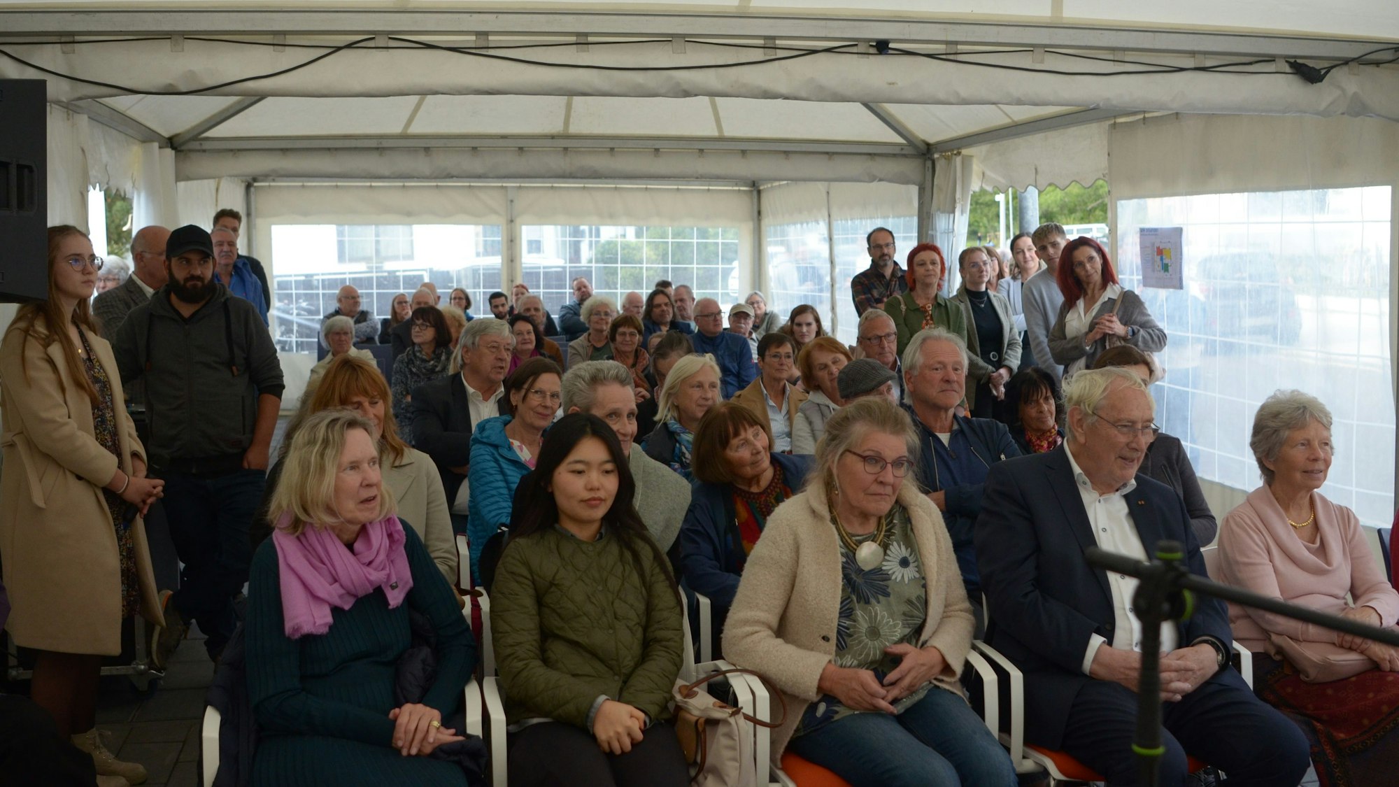 In einem Zelt sitzen und stehen die Gäste, die zur Einweihungsfeier gekommen waren.