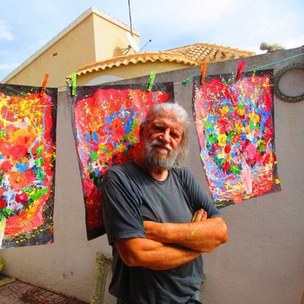 Maler Eugen Daub vor einigen seiner bunten Bilder.