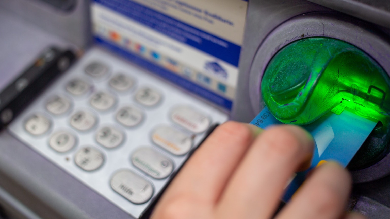 Eine Bankkundin steckt ihre Girokarte in einen Geldautomaten. (Symbolbild)