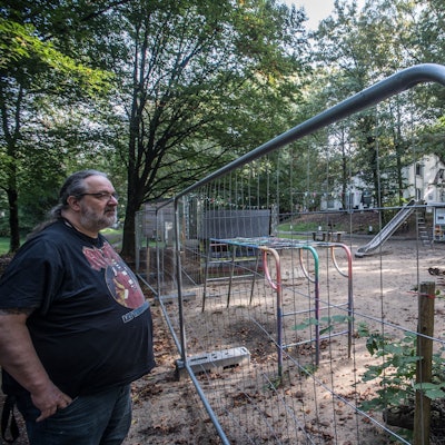 Reinhold Pupka steht an einem Bauzaun auf dem Gelände der Naturfreunde.