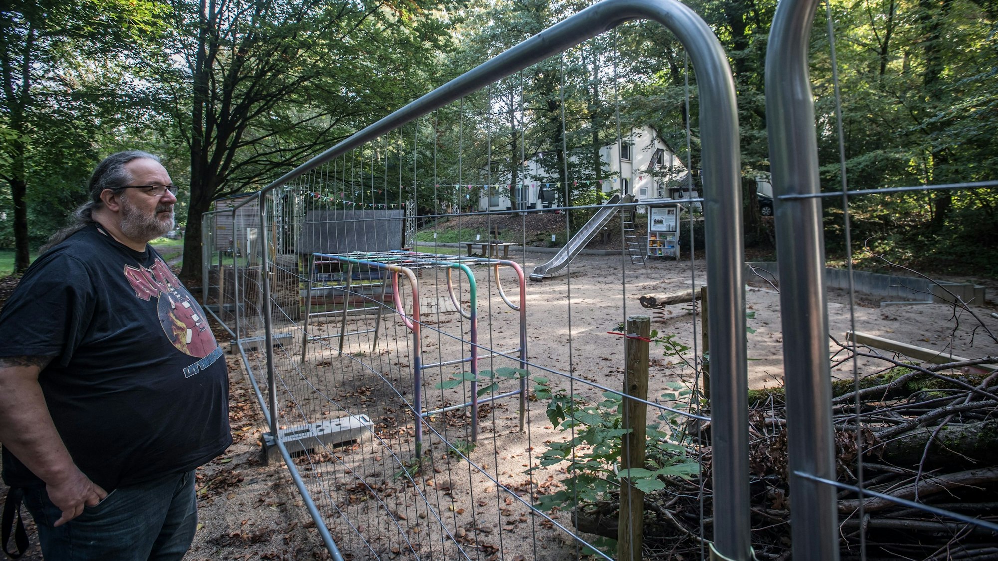 Reinhold Pupka steht an einem Bauzaun auf dem Gelände der Naturfreunde.