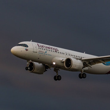Ein Airbus A320 der deutschen Fluggesellschaft Eurowings startet während eines Unwetters in die Luft. Im Hintergrund sind dunkle Wolken zu sehen. (Symbolbild)