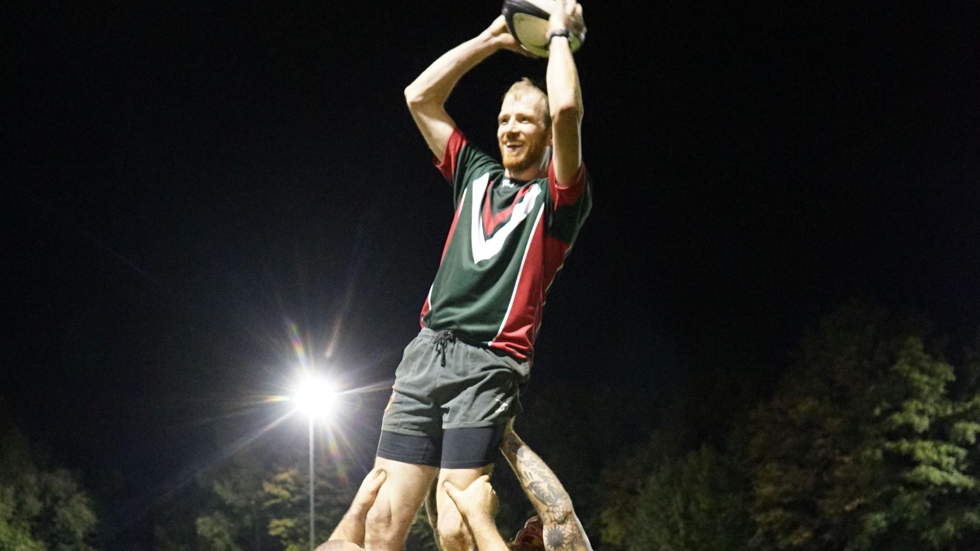 Ein Mann mit einem Ball in der Hand wird hochgehoben.
