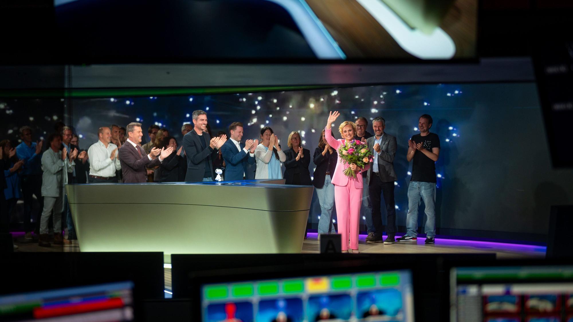 Moderatorin Caren Miosga winkt den Zuschauern am Ende ihrer letzten Sendung im Studio umringt von Mitarbeitern.