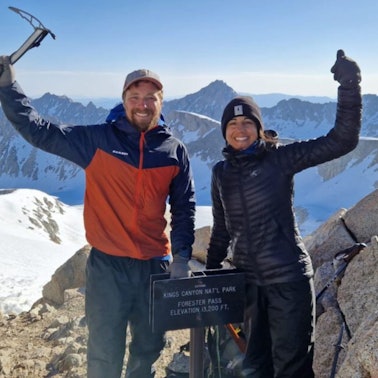 Die beiden Wanderer David Flitsch und Miriam Wiesner winken in die Kamera, sie stehen auf dem Forester Pass im Kings Canyon National Park.