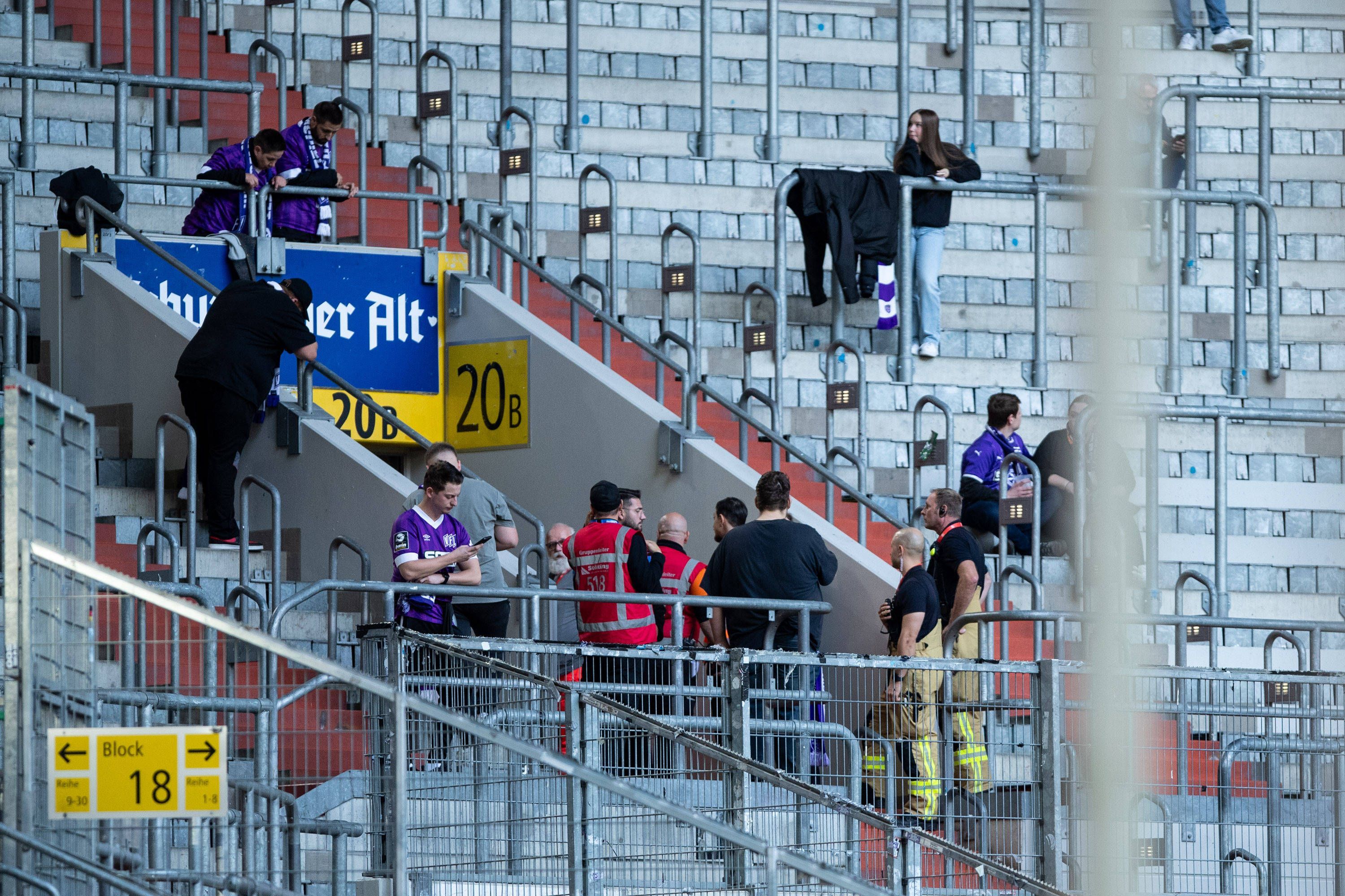 Bange Minuten in Düsseldorf: Fans und Sicherheitsdienst stehen neben Eingang zum Auswärtsblock, wo ein gestürzter Fan medizinisch versorgt wird.