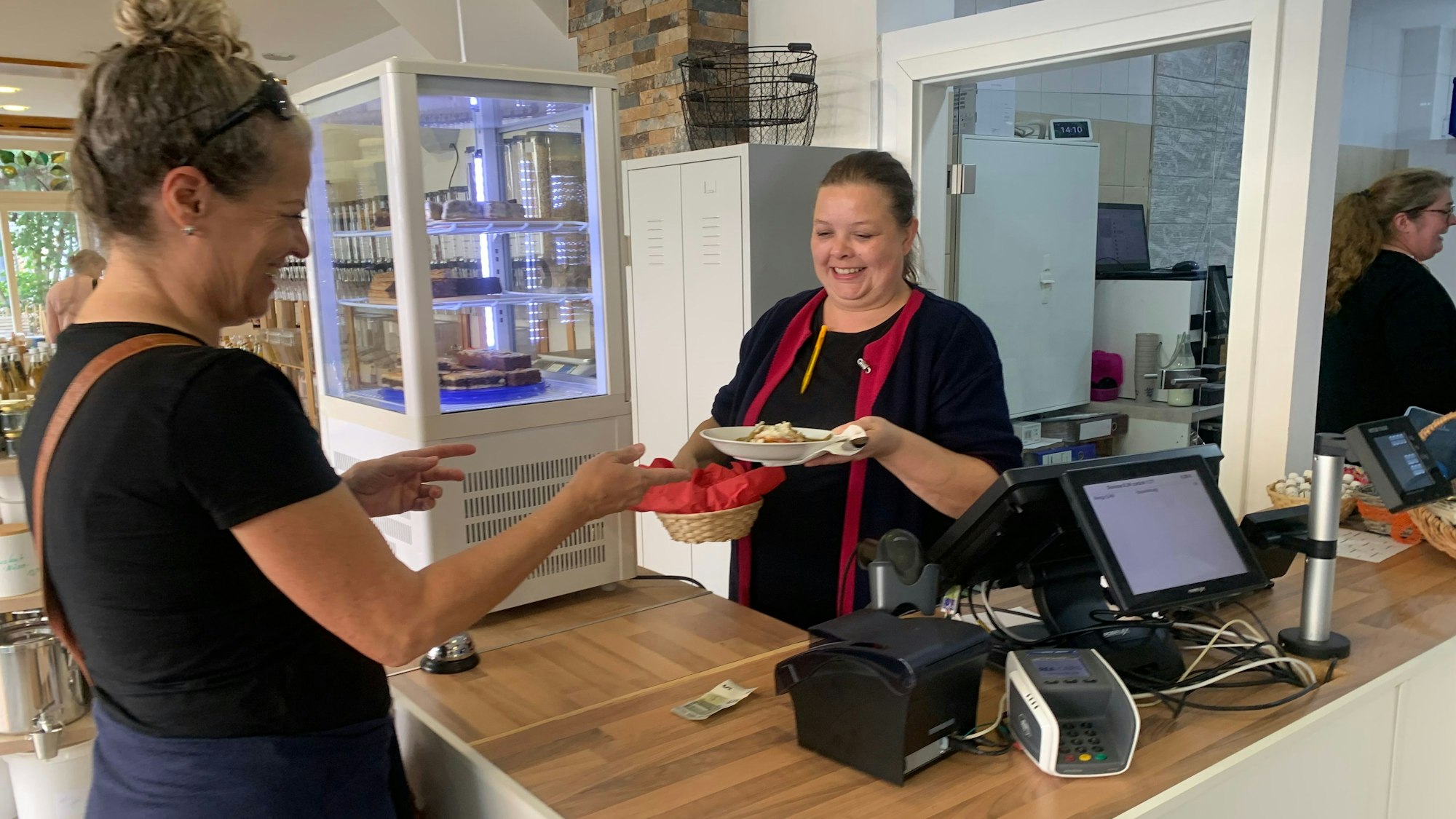 Regina Hopp-Konrad (r.) reicht einer Kundin einen Teller Minestrone, die sie selber gekocht hat.