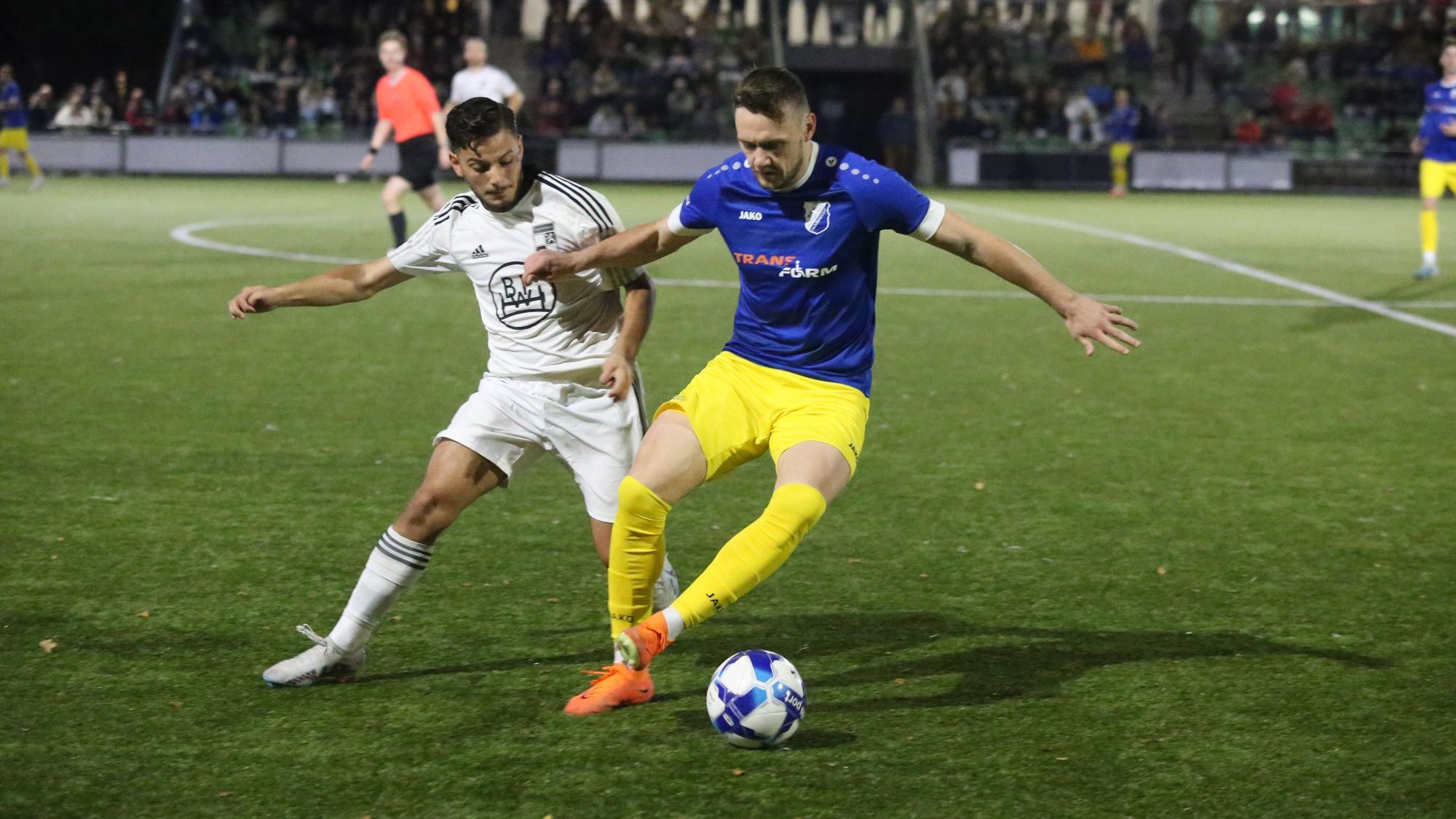 Zwei gegnerische Fußballspieler in Kampf um den Ballgewinn.