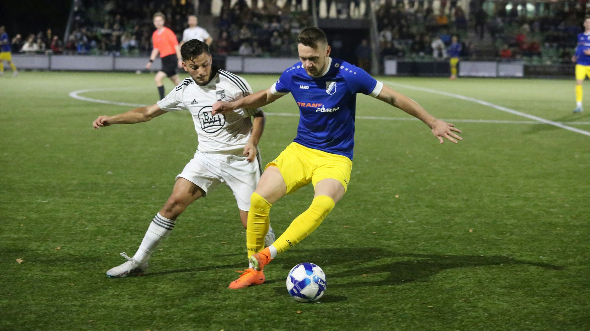 Zwei gegnerische Fußballspieler in Kampf um den Ballgewinn.