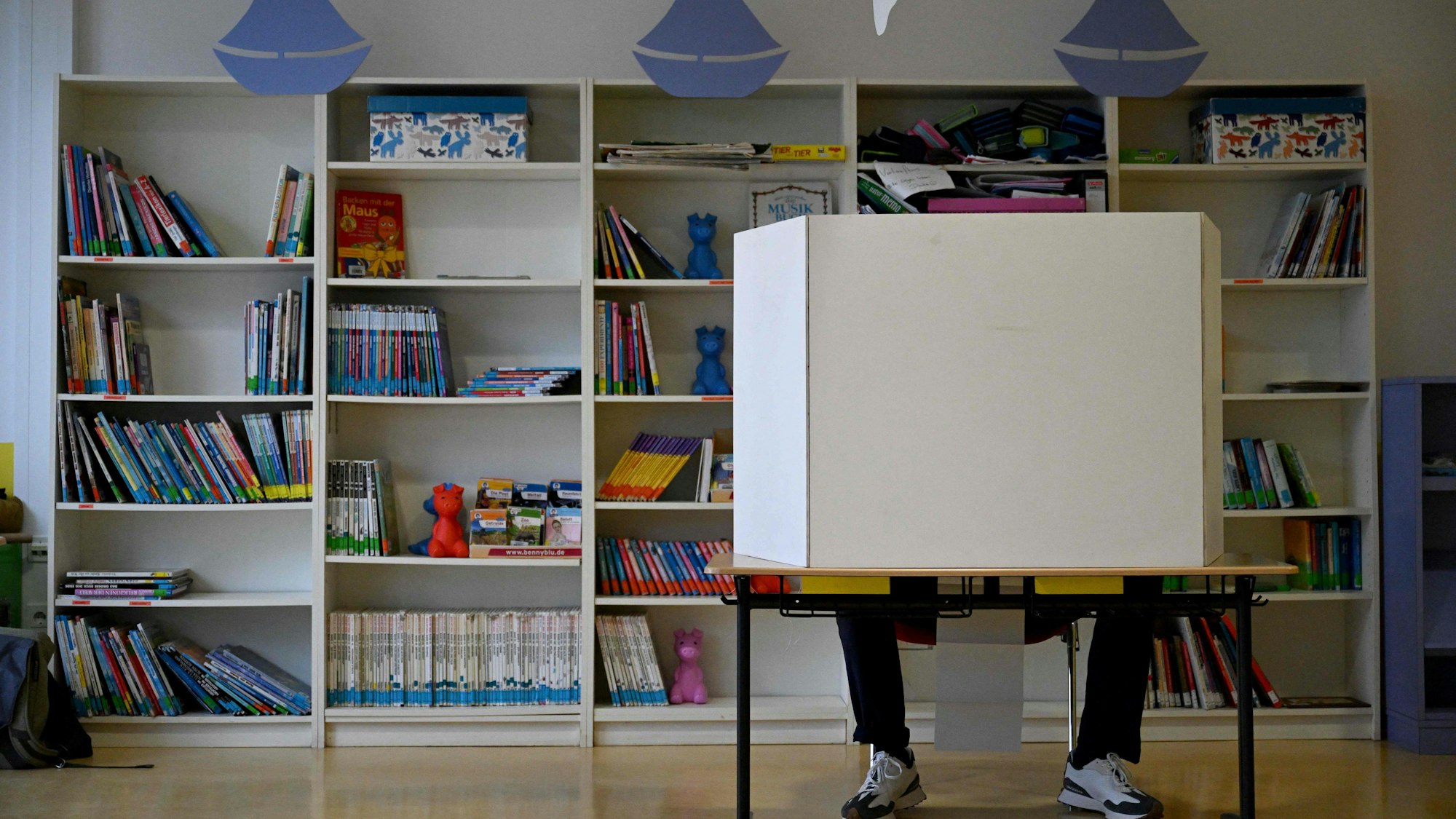 A voter sits in a voting box and fills out the ballot papers at a polling station in Schwalbach am Taunus, western Germany, during regional elections in the western federal state of Hesse on October 8, 2023. Almost 14 million people are eligible to cast ballots in southern Bavaria, the country's biggest state, and western Hesse, with a surge in immigration and economic woes among key topics. (Photo by Kirill KUDRYAVTSEV / AFP)