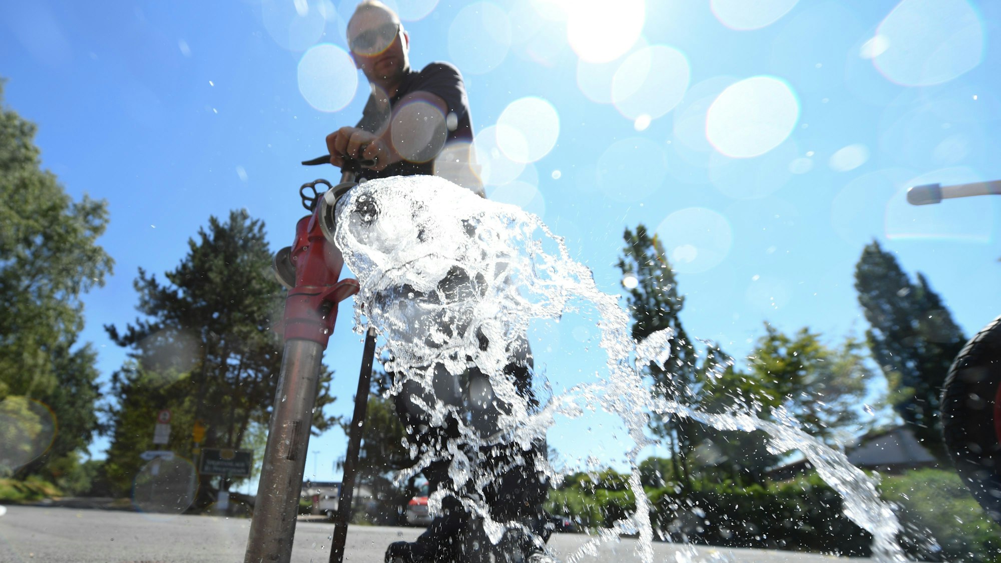 Jan Herbert von der Freiwilligen Feuerwehr dreht beim Einrichten einer Notleitung zur Trinkwasserversorgung des Ortes einen Hydranten auf. (Symbolbild)