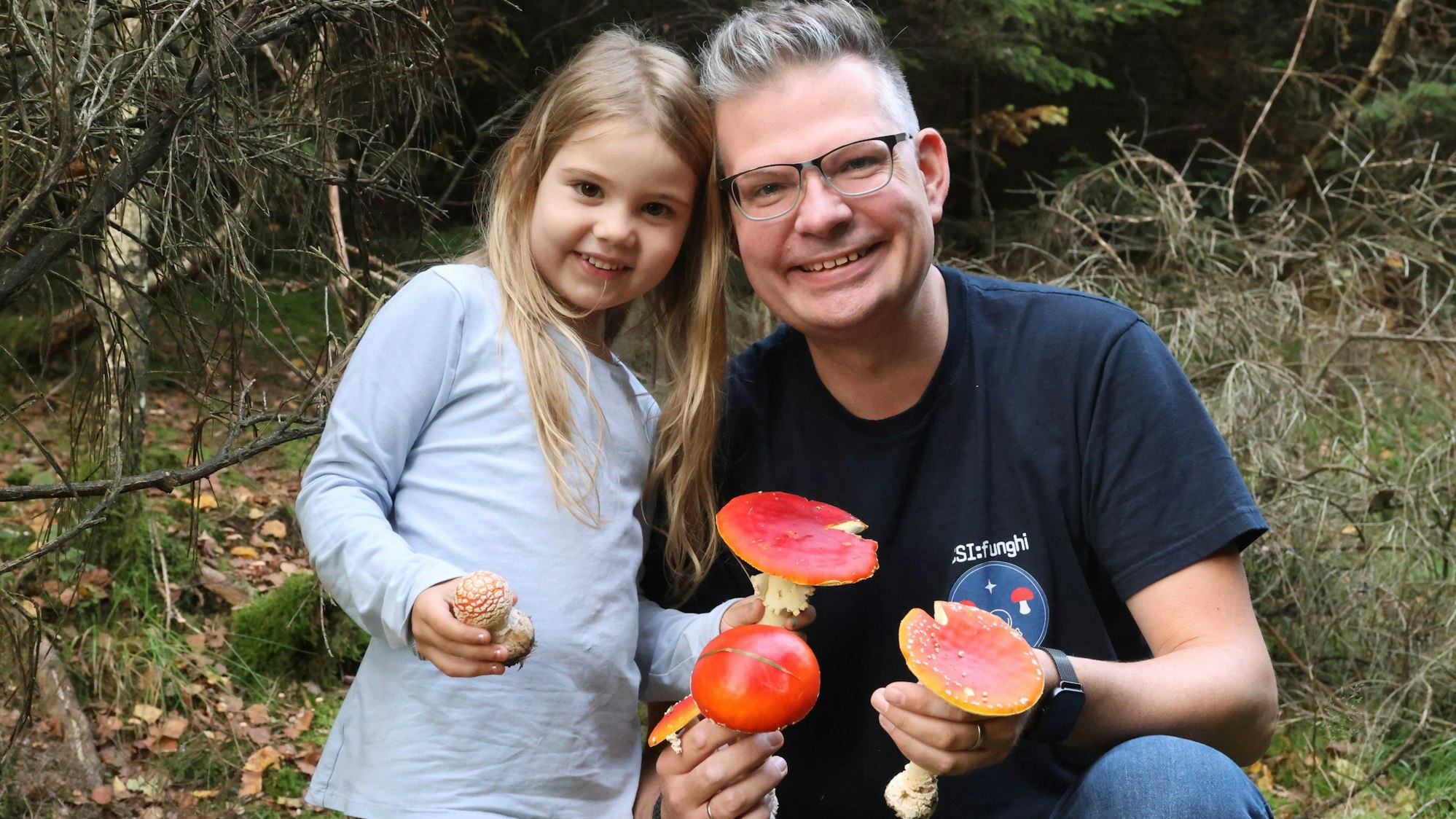 Juliana und Daniel Frank zeigen Fliegenpilze.