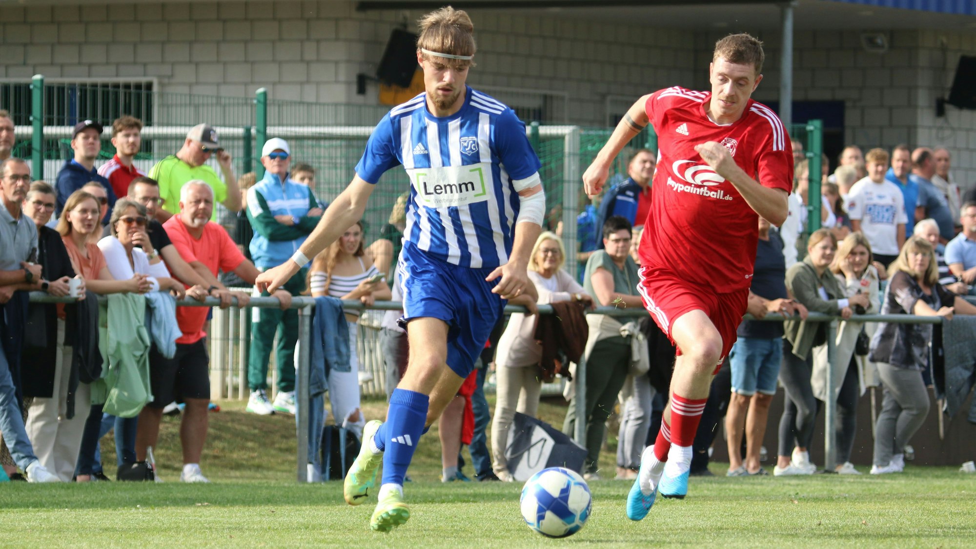 Die beiden tabellarisch besten Teams im Kreis sind der TuS Zülpich und der SC Wißkirchen, hier mit Jan-Niklas Breuer (l.) und Toptorjäger Dominik Spies im Laufduell. Im Hintergrund sind viele Zuschauer zu erkennen.