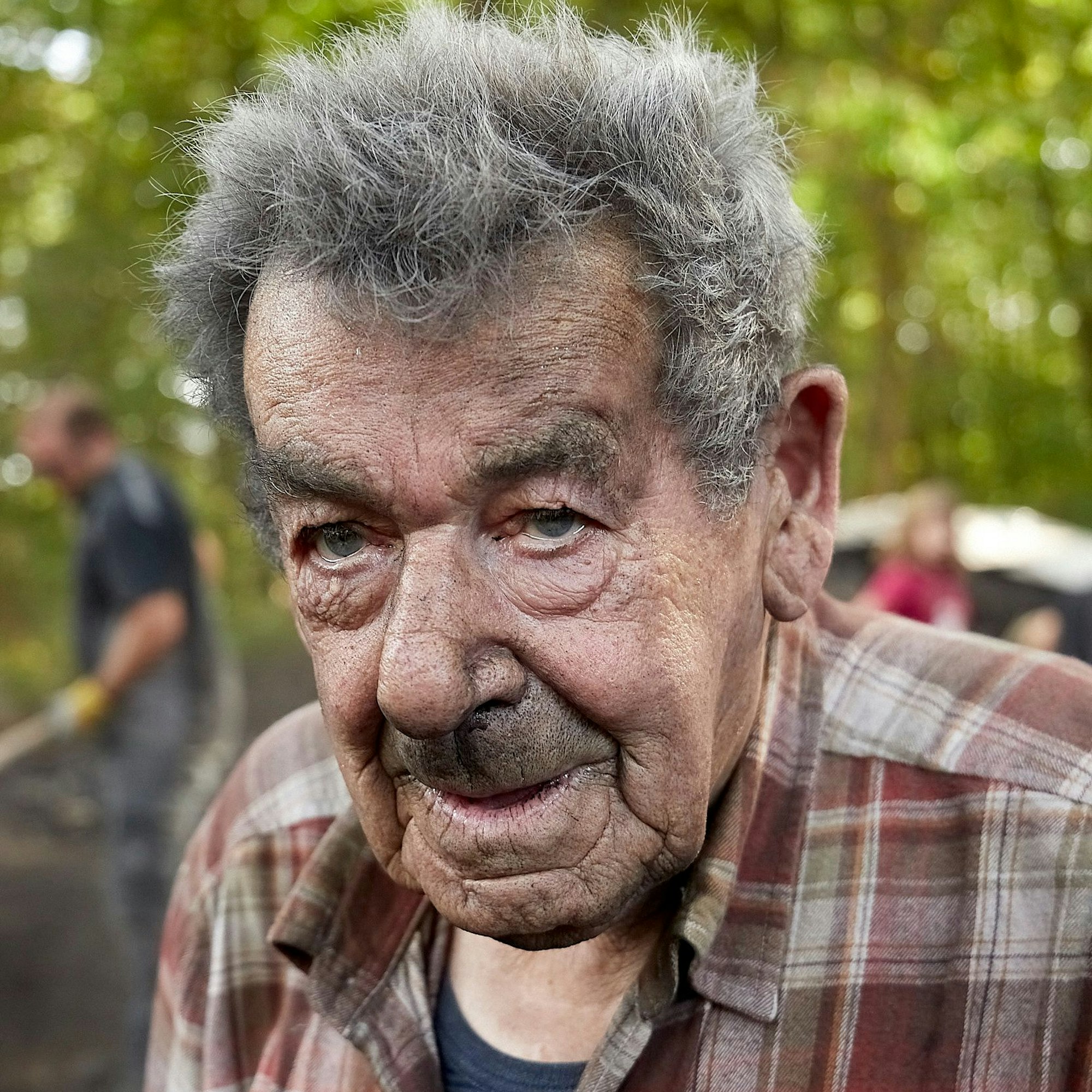 Ein Porträt des Mannes mit grauem Haar und rußverschmiertem Gesicht.
