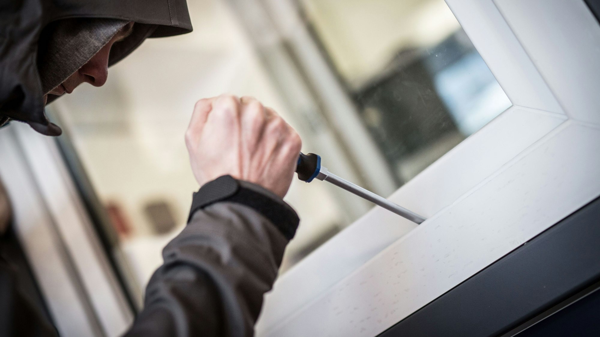 Ein Mann demonstriert in der polizeilichen Beratungsstelle, wie Einbrecher Fenster aufhebeln.