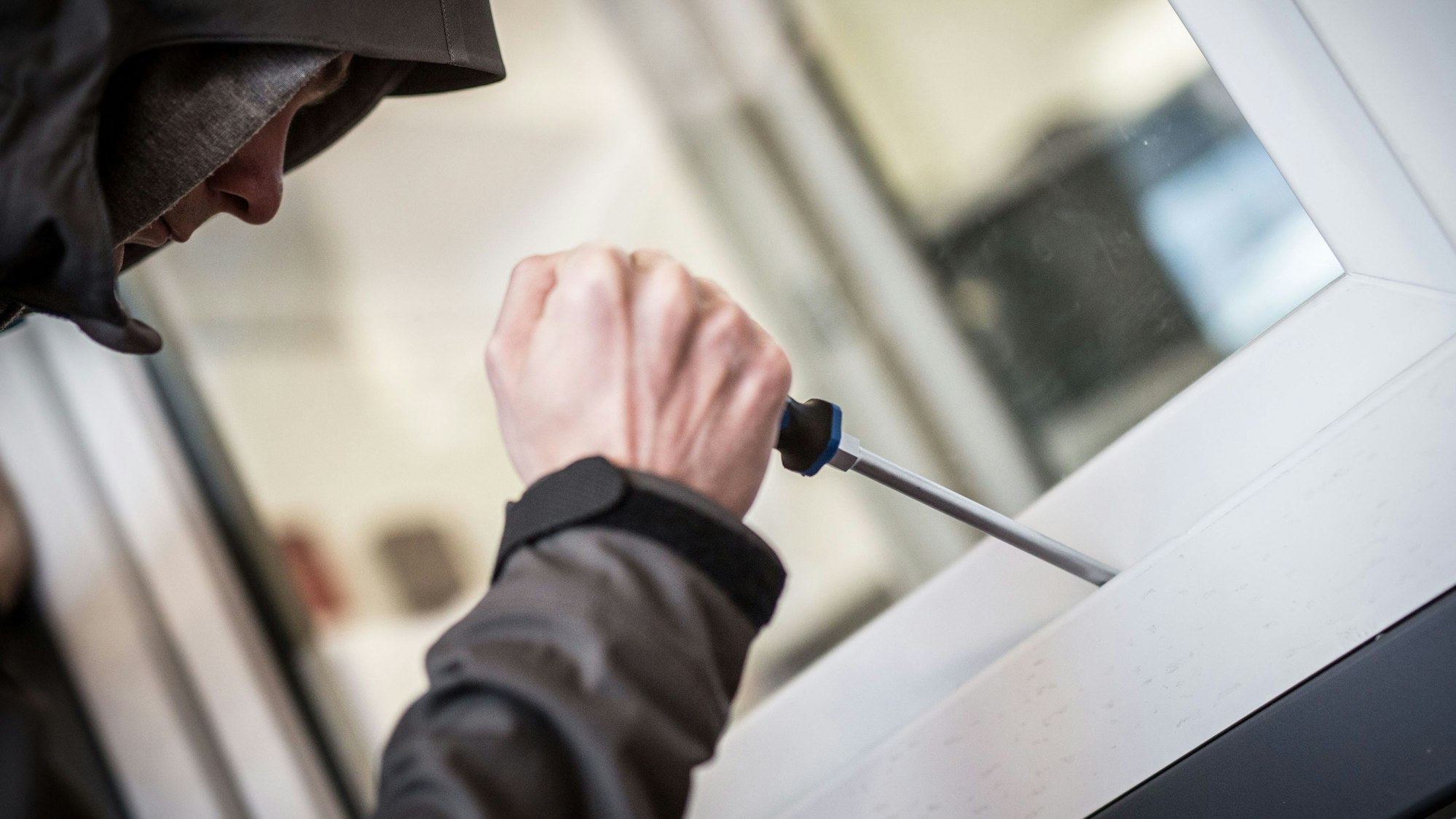 Ein Mann demonstriert in der polizeilichen Beratungsstelle, wie Einbrecher Fenster aufhebeln.