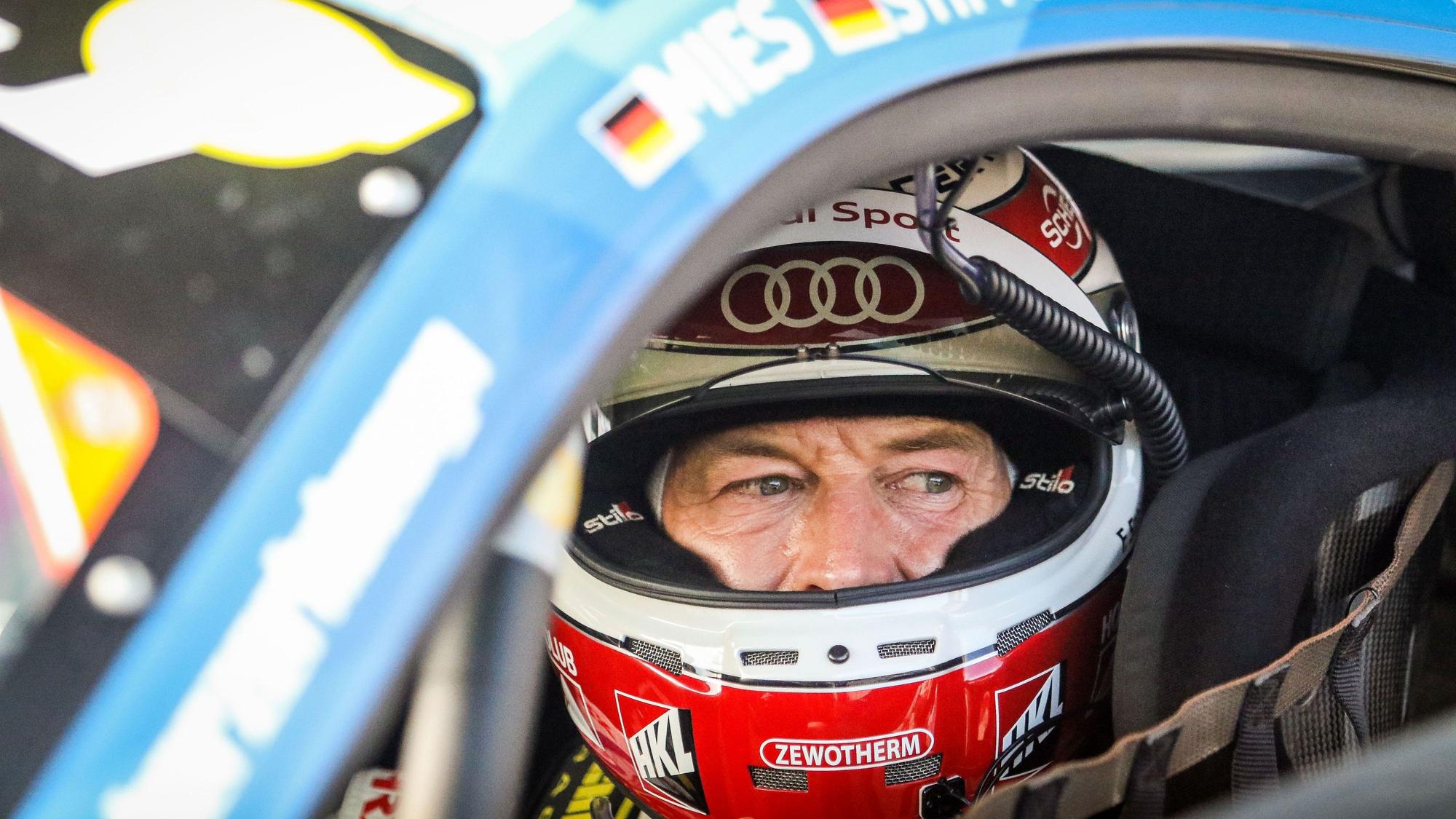 Frank Stippler sitzt in seinem Rennauto und trägt einen Helm. Er blickt aus dem geöffneten Seitenfenster.