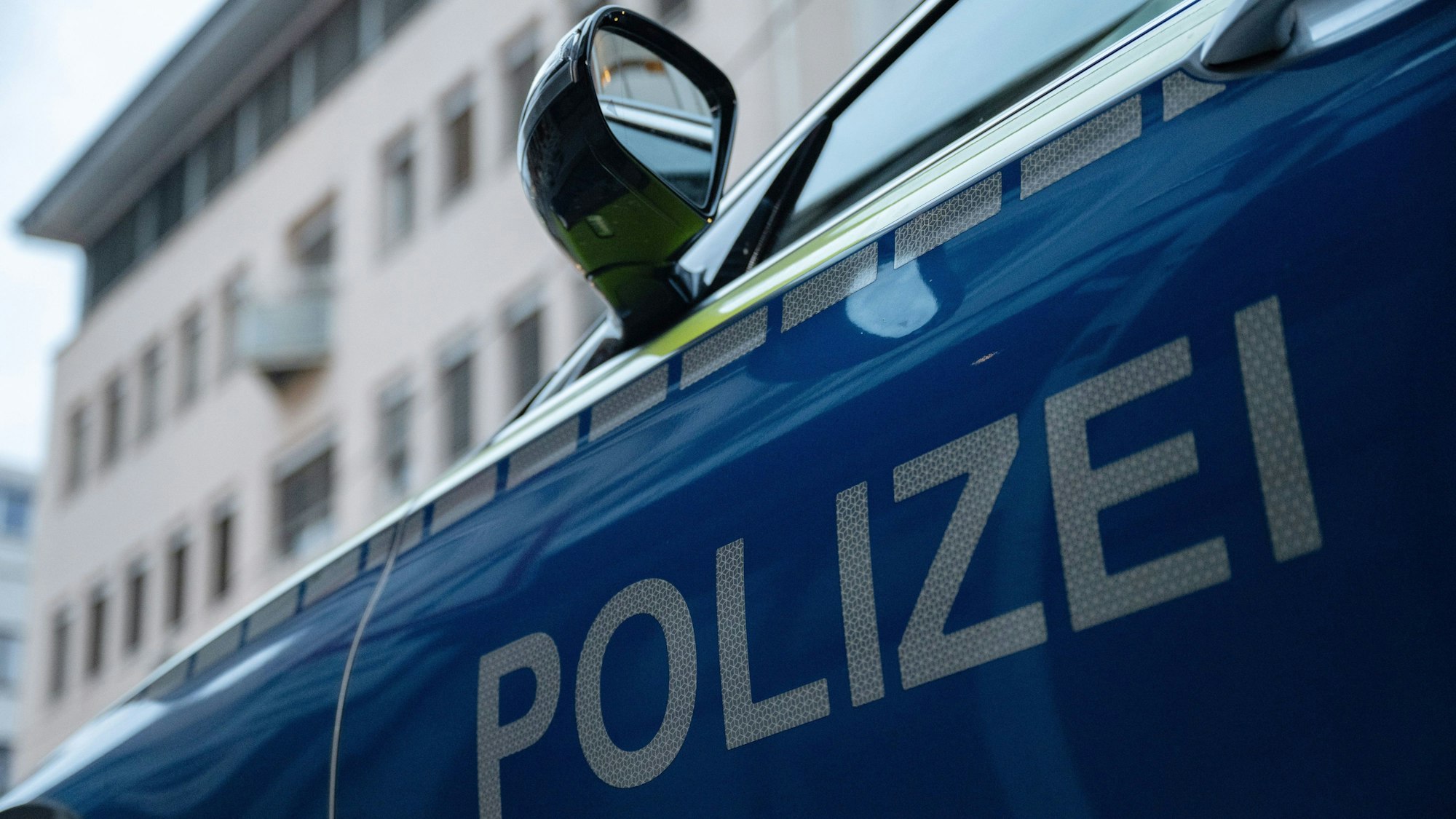 Ein Streifenwagen der Polizei steht vor einem Gebäude. (Symbolbild)