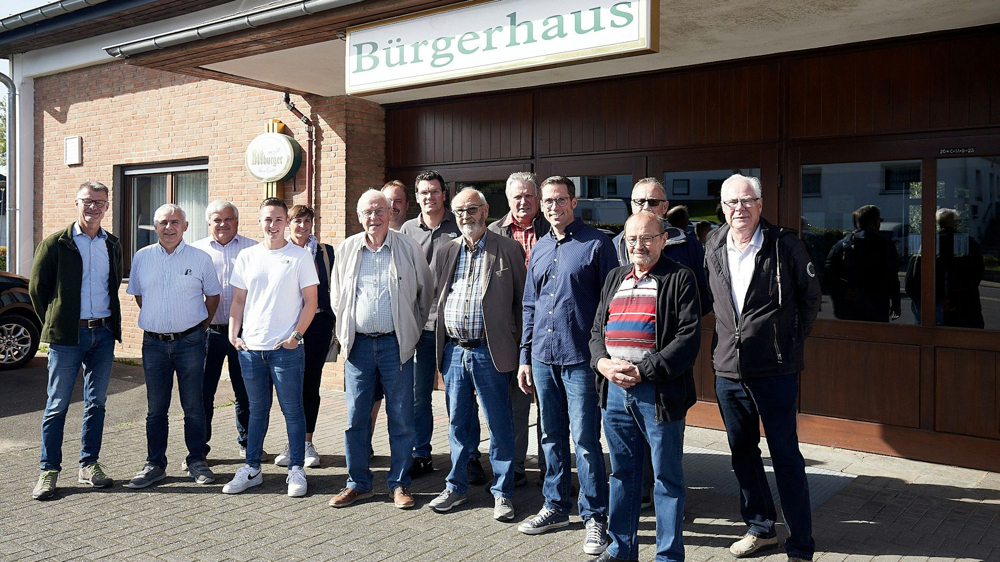 Der alte und der neue Vorstand des Bürgerhausvereins sowie Bürgermeister Jan Lembach (l.) und Ortsbürgermeister Hans-Josef Bohnen (2.v.l.) stehen vor einem Haus. Über dem Eingang ist der Schriftzug Bürgerhaus zu lesen.