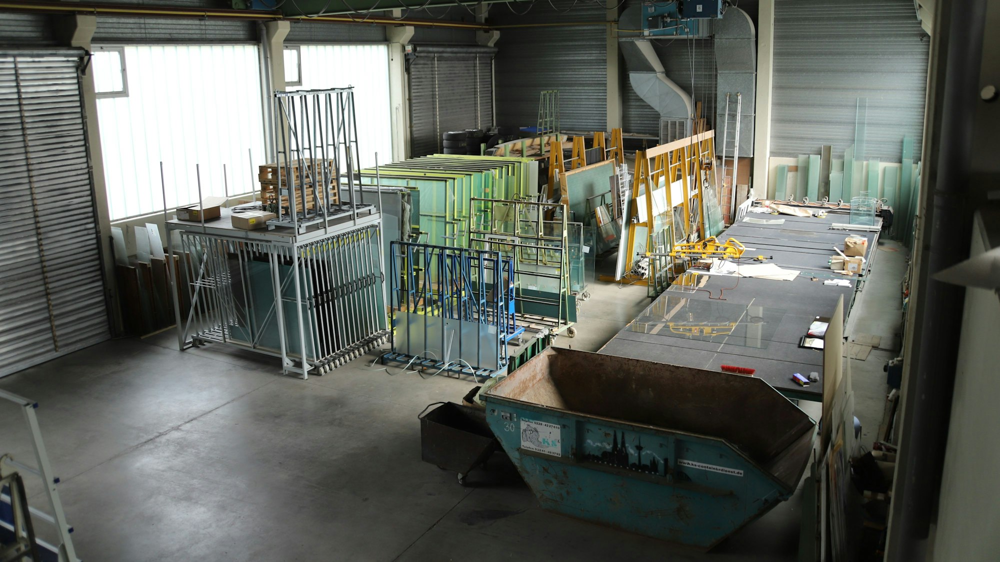 Karl-Heinz Decker (83) übergibt seinen Betrieb für Glasarbeiten an seinen Enkel Max (19). In der Halle lagern Glasscheiben unterschiedlicher Größen und Qualitäten, die auf dem großen Zuschnitt-Tisch (rechts im Bild) bearbeitet werden können.