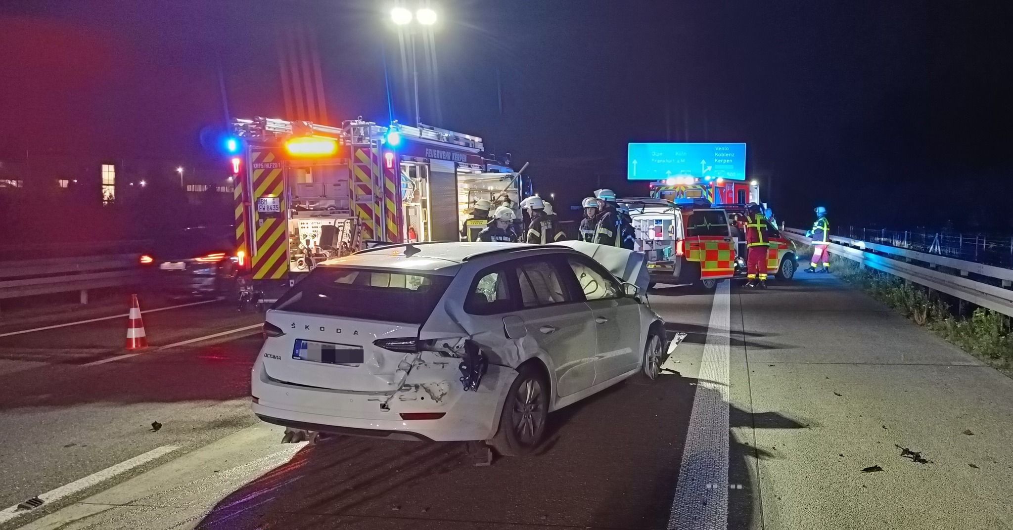Auf dem Foto sind mehrere Einsatzfahrzeuge der Feuerwehr und eines der am Unfall beteiligten Fahrzeuge zu sehen.
