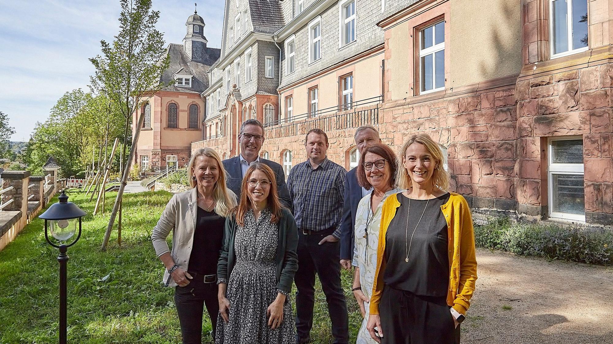 Einige Männer und Frauen stehen vor dem ehemaligen Kloster in Nettersheim. Die Kinderpsychologinnen Sandra Krömer (2.v.l.) und Ulrike König (r.) haben dort eine Praxis eröffnet.