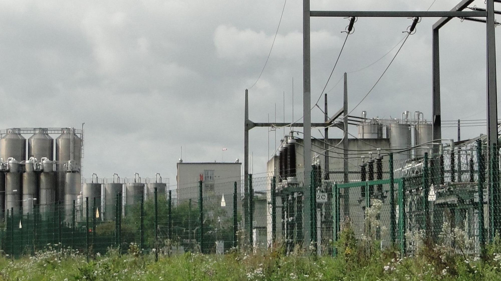 Ein Umspannwerk ist vor einem Chemie-Unternehmen zu sehen.