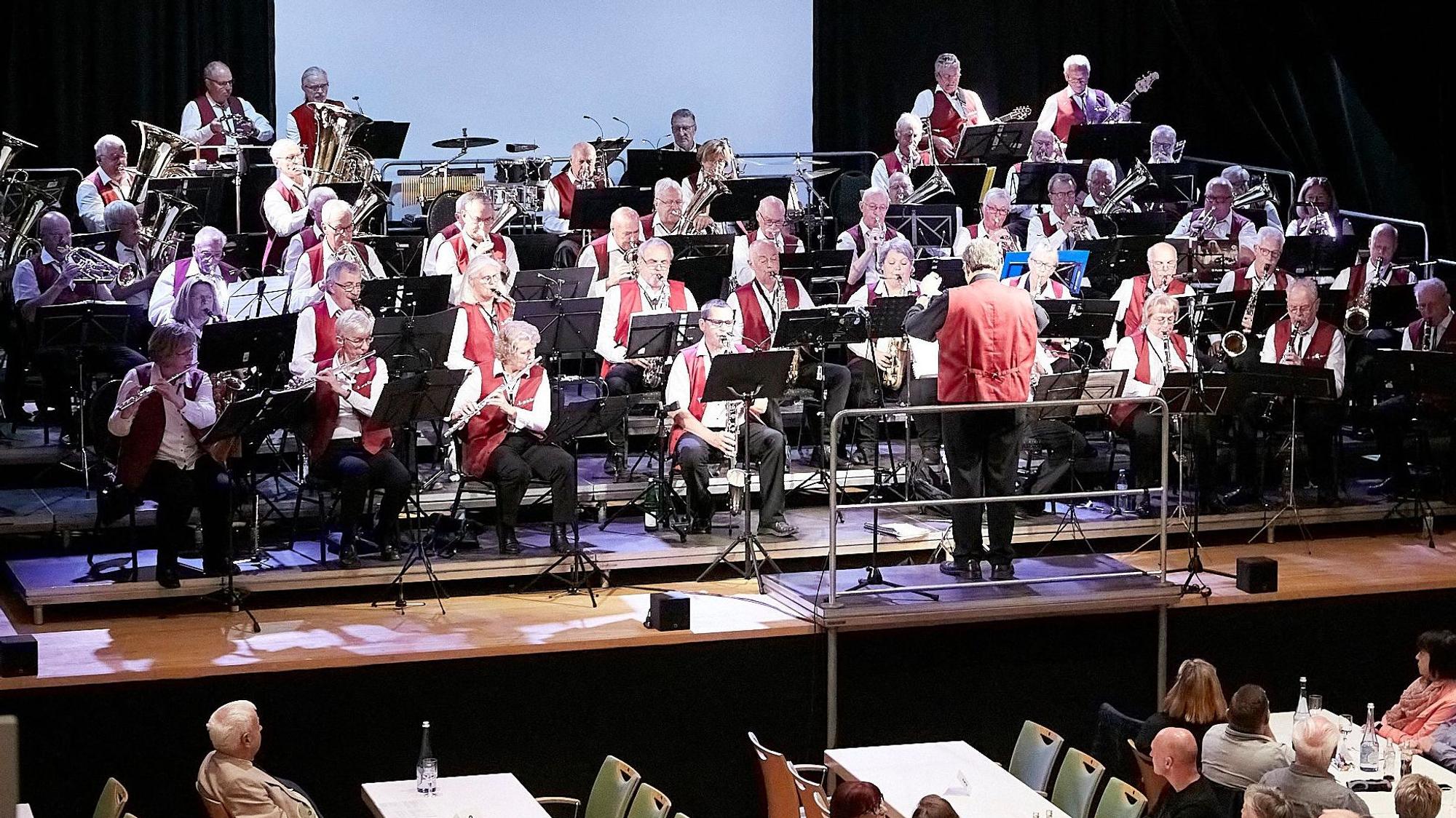 Die Musiker des Ü-50-Orchesters sitzen auf der Bühne im Gemünder Kursaal und musizieren.