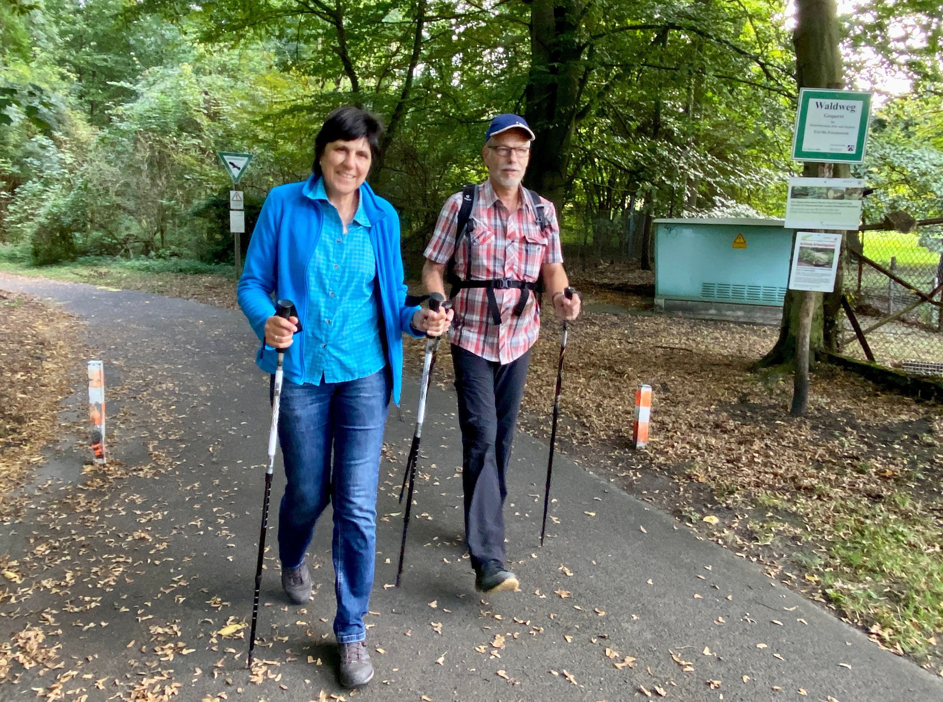 Das Foto zeigt die beiden Wanderer Ute und Michael Pliester, im Hintergrund ist der herbstliche Wald zu sehen.