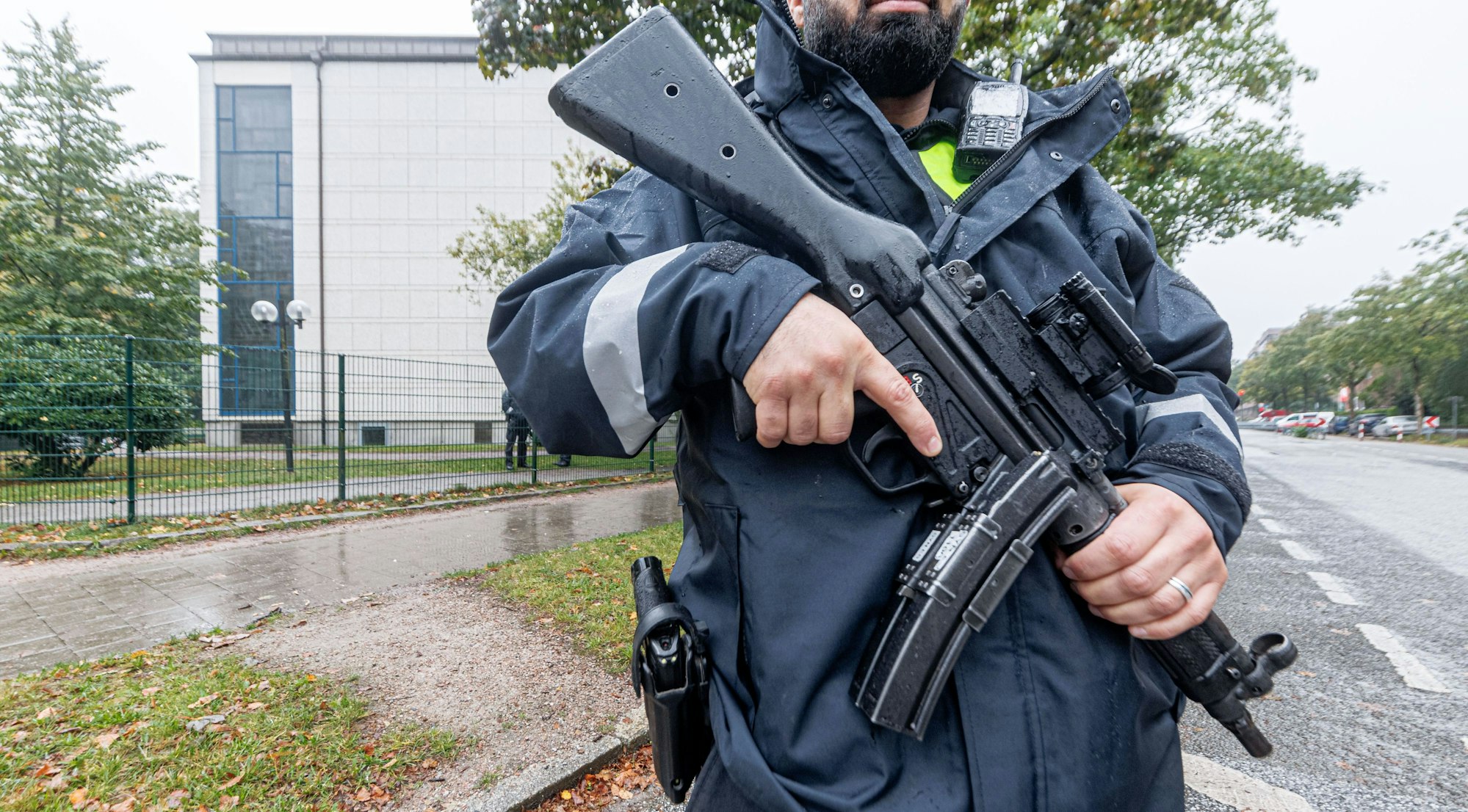 09.10.2023, Hamburg: Ein Polizist mit Maschinenpistole bewacht mit anderen nach dem Angriff der Hamas auf Israel die jüdische Synagoge in Hamburg.